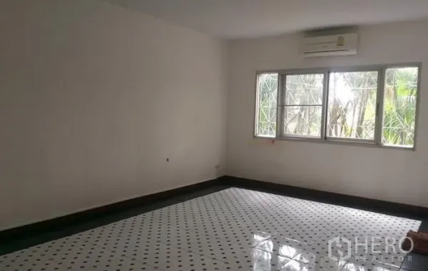 联排别墅 出租在Wang Thonglang, Bangkok - 曼谷旺通朗联排别墅内，明亮房间配图案地砖、大窗与壁挂空调。