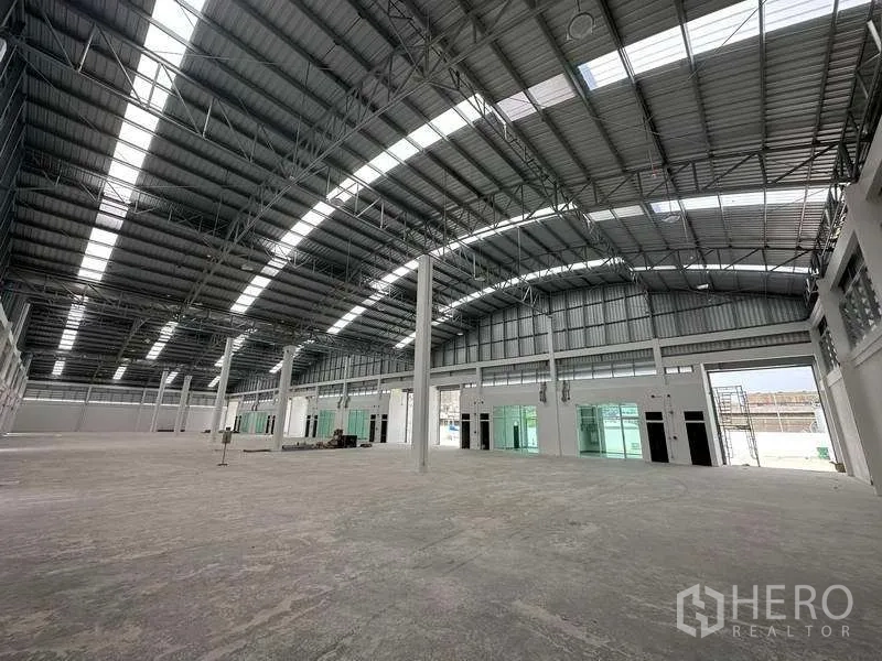 Factory for rent in Khlong Luang, Pathum Thani - Open-plan warehouse interior showing clear-span structure and multiple loading doors.