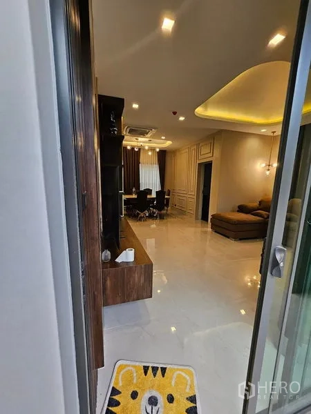 独立式住宅 出售在Mueang Pathum Thani, Pathum Thani - 从入口望向客餐厅，亮面地砖与筒灯照明。