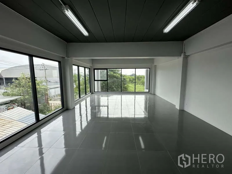 Factory for rent or sale in Bang Bua Thong, Nonthaburi - Bright office level with panoramic glazing overlooking trees.