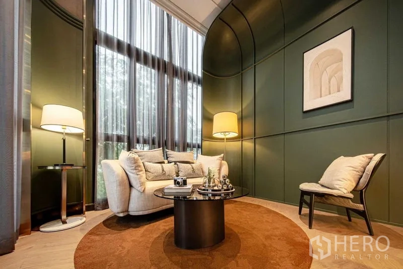 Detached House for sale in Saphan Sung, Bangkok - Cozy lounge with curved green feature wall, tall curtains, soft lighting and round rug.