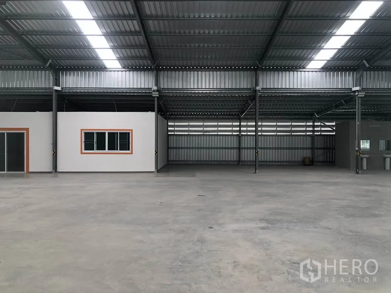 Warehouse for rent in Mueang Nonthaburi, Nonthaburi - Centered view of the warehouse hall with two internal office pods and expansive floor area.