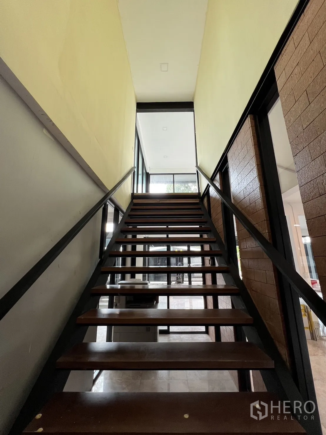 Detached House for rent or sale in Phra Khanong, Bangkok - Staircase with wooden treads and black steel railing leading to the upper floor.