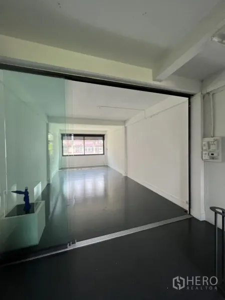 Shophouse for rent or sale in Watthana, Bangkok - Bright office room behind sliding glass partition with a large window.