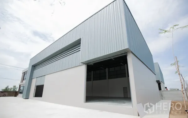 工厂 出租或出售在Nakhon Pathom - 大型钢结构仓库外立面，宽幅卷帘门与装卸场。