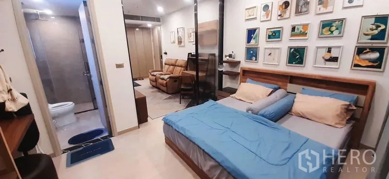 Condominium for rent or sale in Huai Khwang, Bangkok - Bedroom view toward bathroom and living area through a glass partition.
