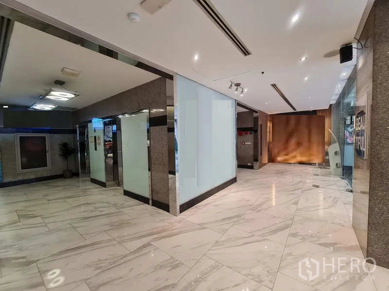 办公空间 出租在Ratchathewi, Bangkok - 办公楼大堂铺设大理石地面，磨砂玻璃隔墙与嵌入式照明，临近BTS Ratchathewi站。