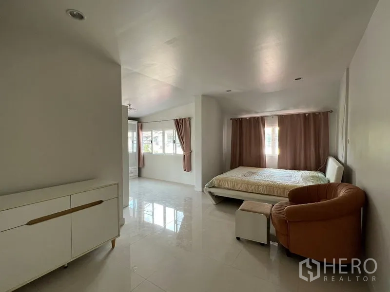 Detached House for rent in Bang Kapi, Bangkok - Large master bedroom with lounge chair, wide windows and blackout curtains.