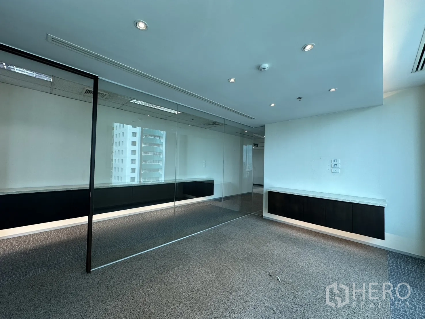 Office Space for rent in Watthana, Bangkok - Bright office room facing city views, glass wall, and floating storage cabinet.