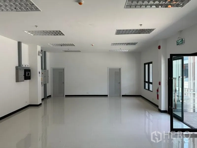 Warehouse for rent in Bang Phli, Samut Prakan - Bright office area with tiled floors, grid lighting and glass entry door.