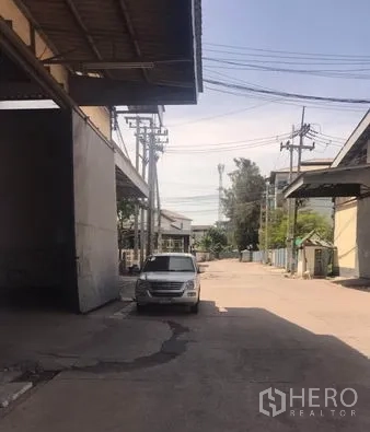 货栈 出租在Chachoengsao - 仓库区宽阔车道，设电线杆与停车位，适合卡车通行。
