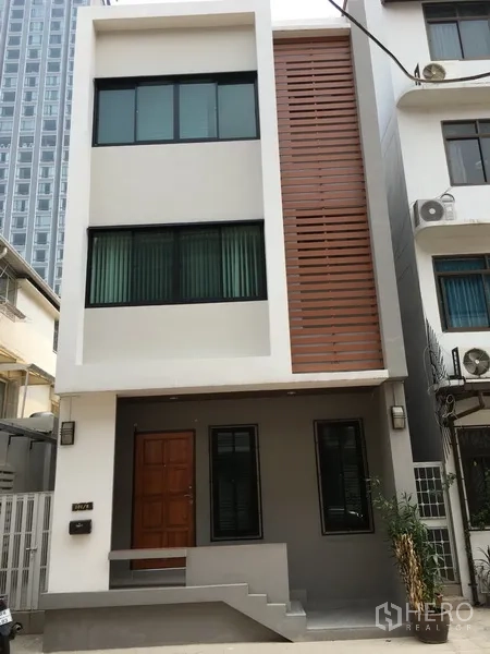 带办公室的家 出租在Bang Rak, Bangkok - 三层现代家办楼外观，木质百叶立面与大窗，位于邦拉克