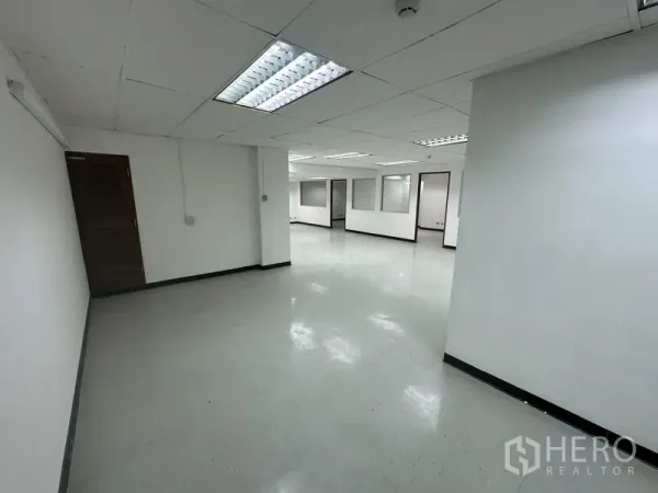 Office Space for rent in Khlong Toei, Bangkok - Spacious white office interior with vinyl flooring and multiple partitioned areas.