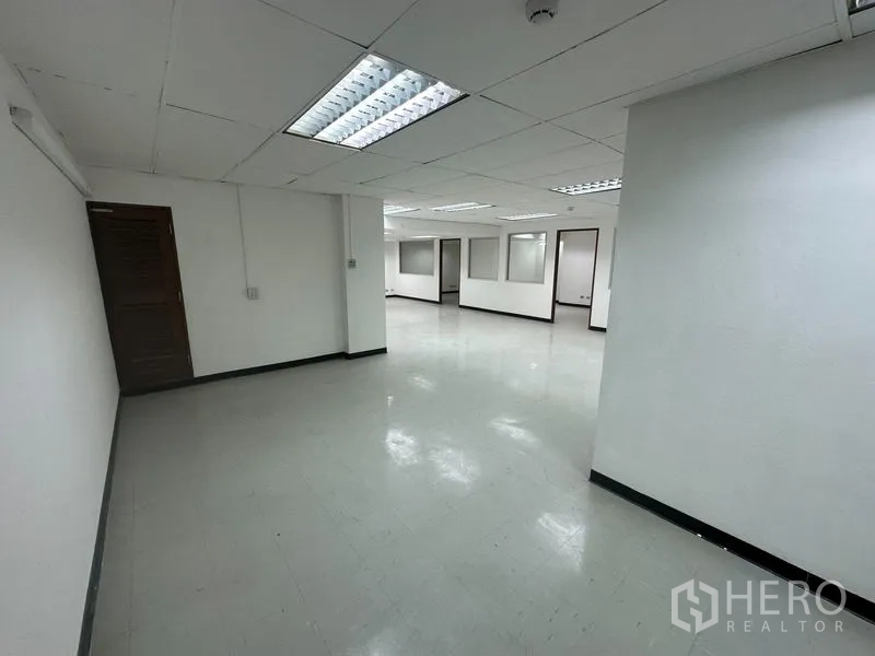 Office Space for rent in Khlong Toei, Bangkok - Spacious white office interior with vinyl flooring and multiple partitioned areas.