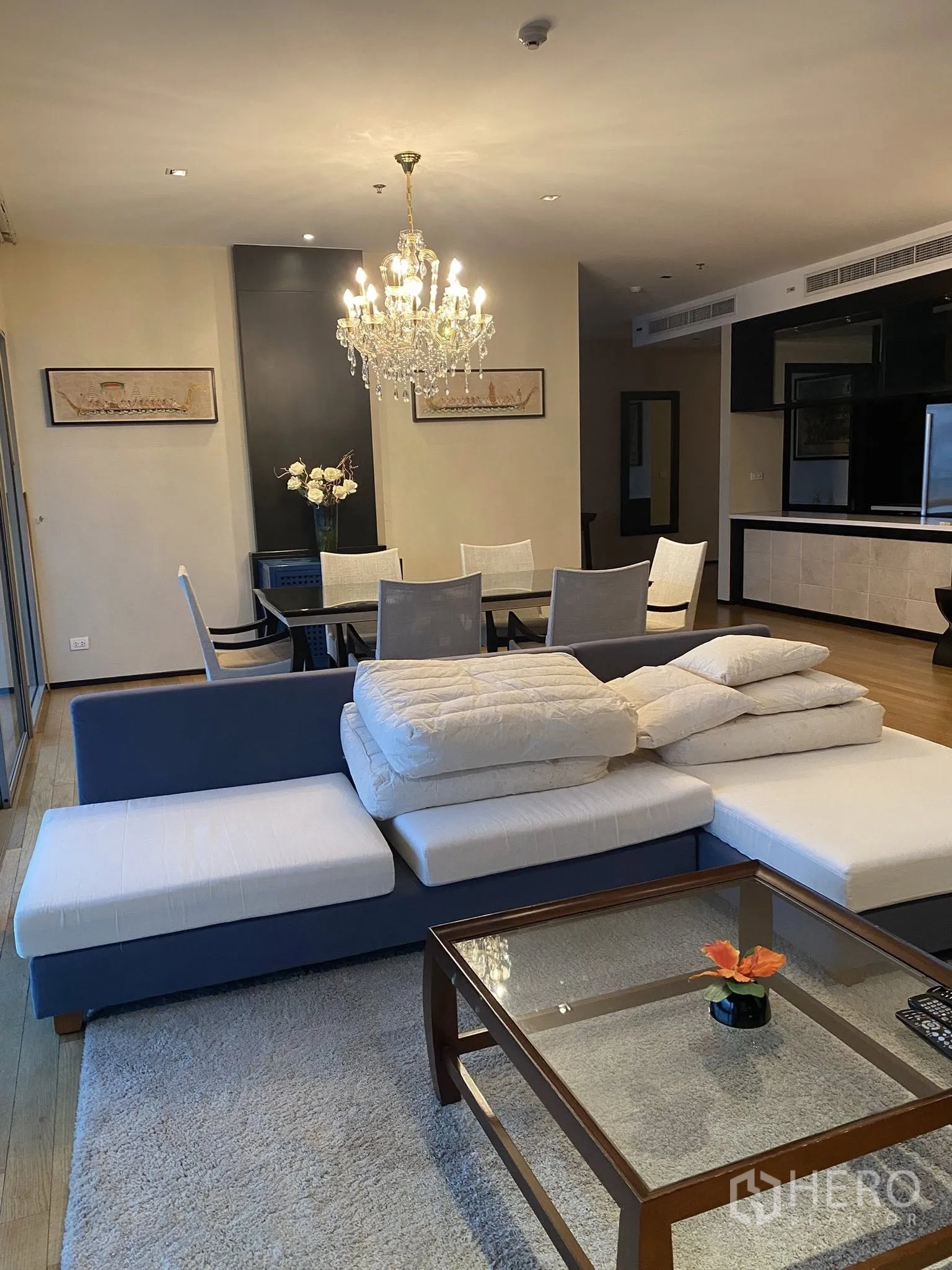 公寓 for rent in Watthana, Bangkok - 开放式客餐厅，水晶吊灯、蓝白色沙发、玻璃茶几与木地板。
