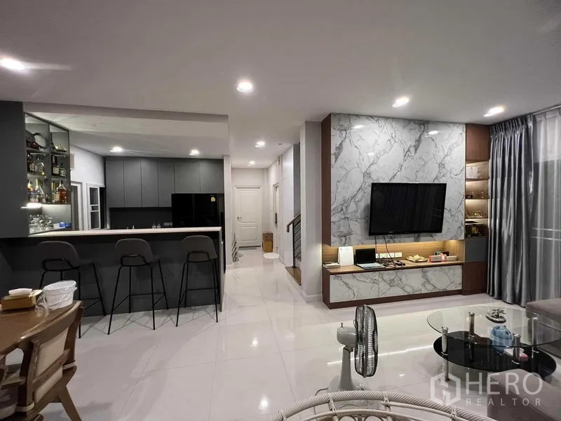 独立式住宅 出租或出售在Lat Krabang, Bangkok - 开放式起居区，面对吧台与灰色一体化厨房。