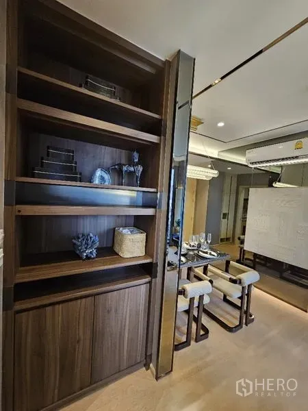 Condominium for rent - Built-in wooden shelving beside glass-top dining table in modern Watthana condominium.