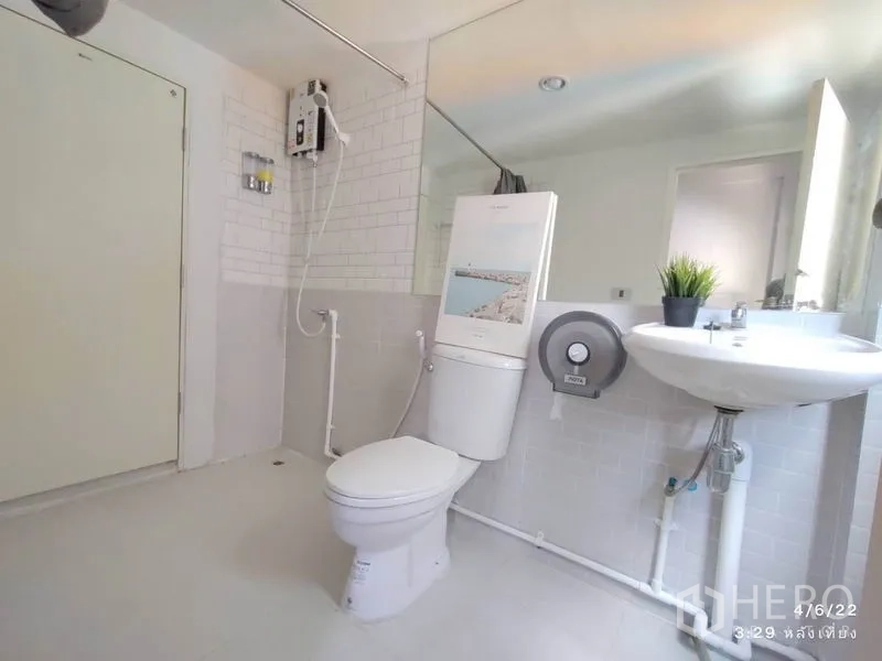 Home Office for rent - Clean bathroom with toilet, basin, large wall mirror and shower water heater.