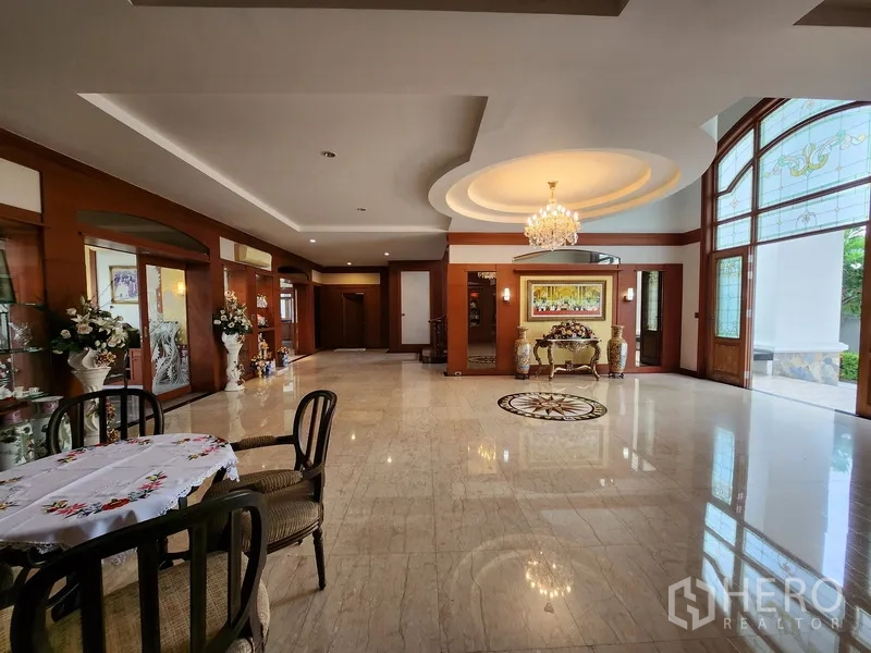 บ้าน ให้เช่าในPrawet, Bangkok - มุมนั่งเล่นใกล้ประตูทางเข้าพร้อมโคมไฟฝ้าหลุมและหน้าต่างโค้งรับแสงธรรมชาติ