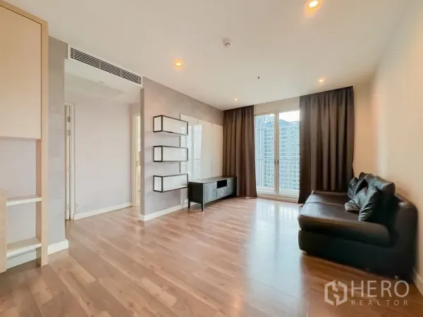 Condominium for sale - Bright living room with wood floors, floating shelves, TV console and balcony doors.