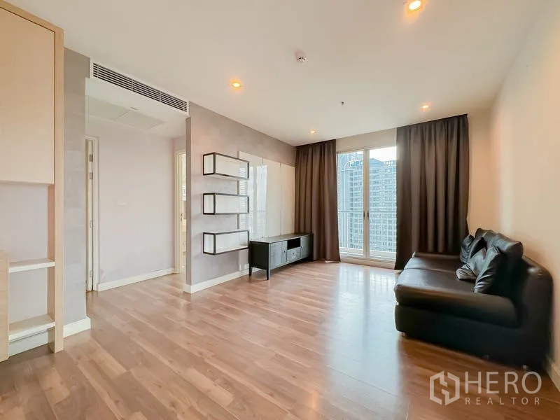 Condominium for sale - Bright living room with wood floors, floating shelves, TV console and balcony doors.