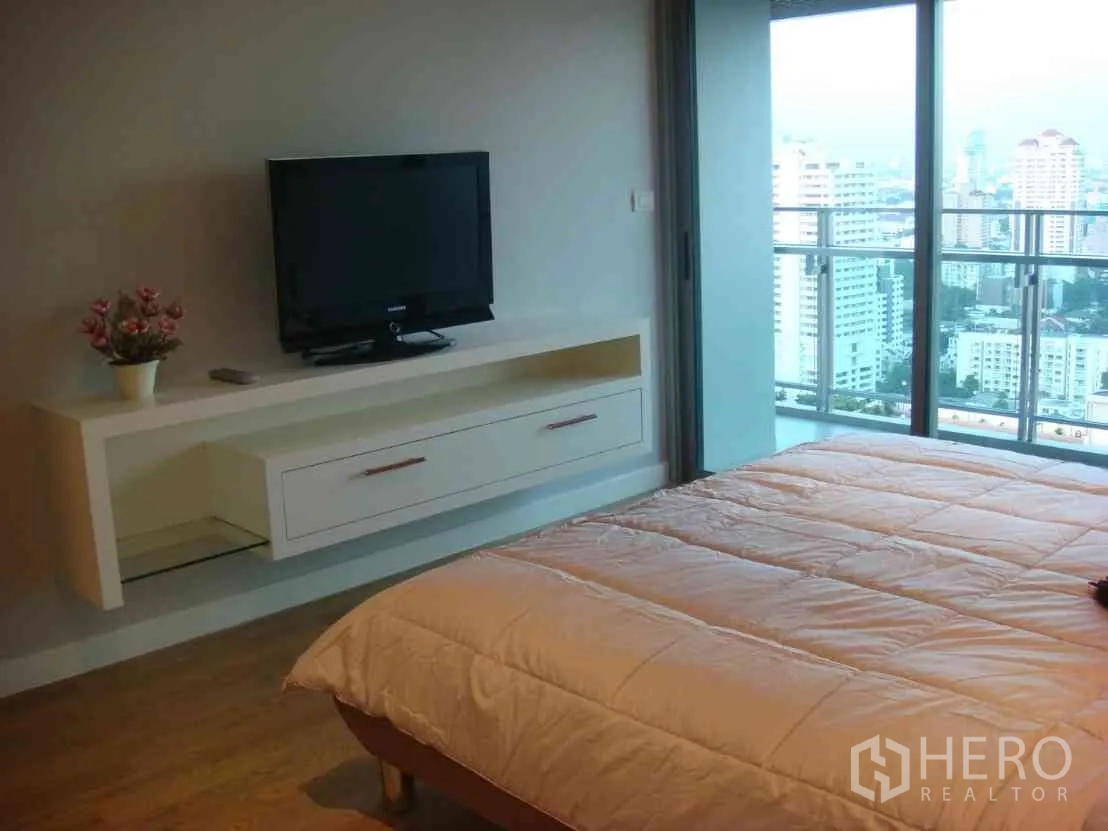 公寓 出租在Watthana, Bangkok - 主卧配电视柜，连接阳台可欣赏曼谷城市天际线。