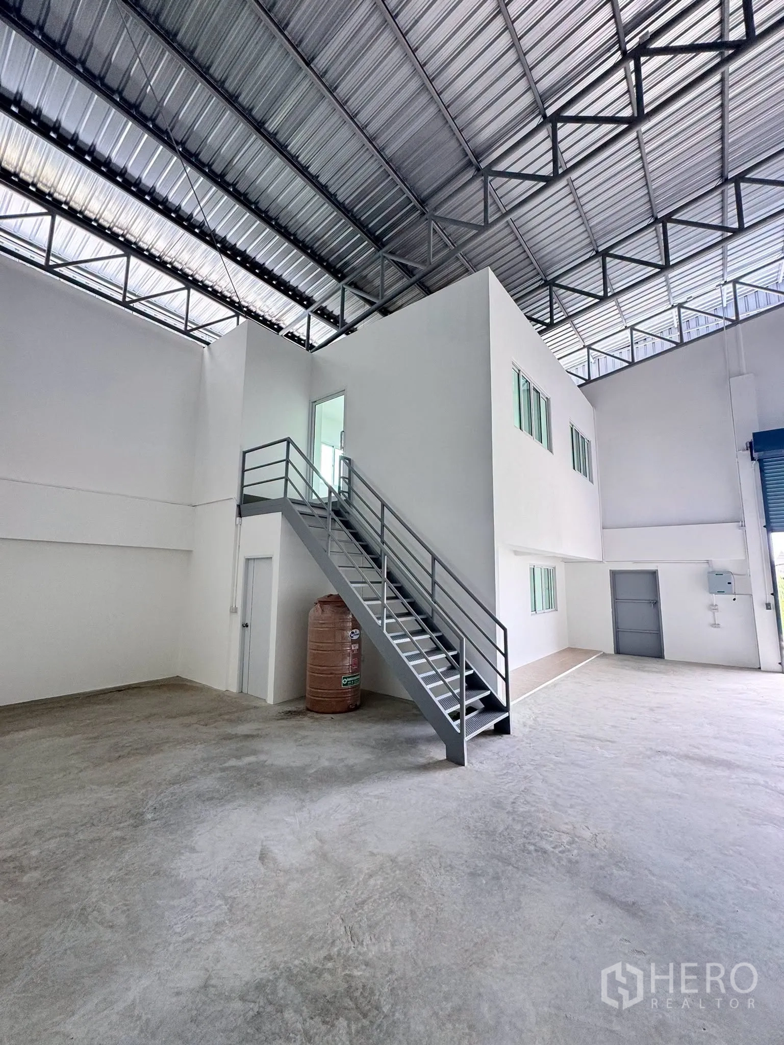 Warehouse for rent in Bang Bo, Samut Prakan - Overall interior highlighting the mezzanine structure, stairs, and clear floor space.