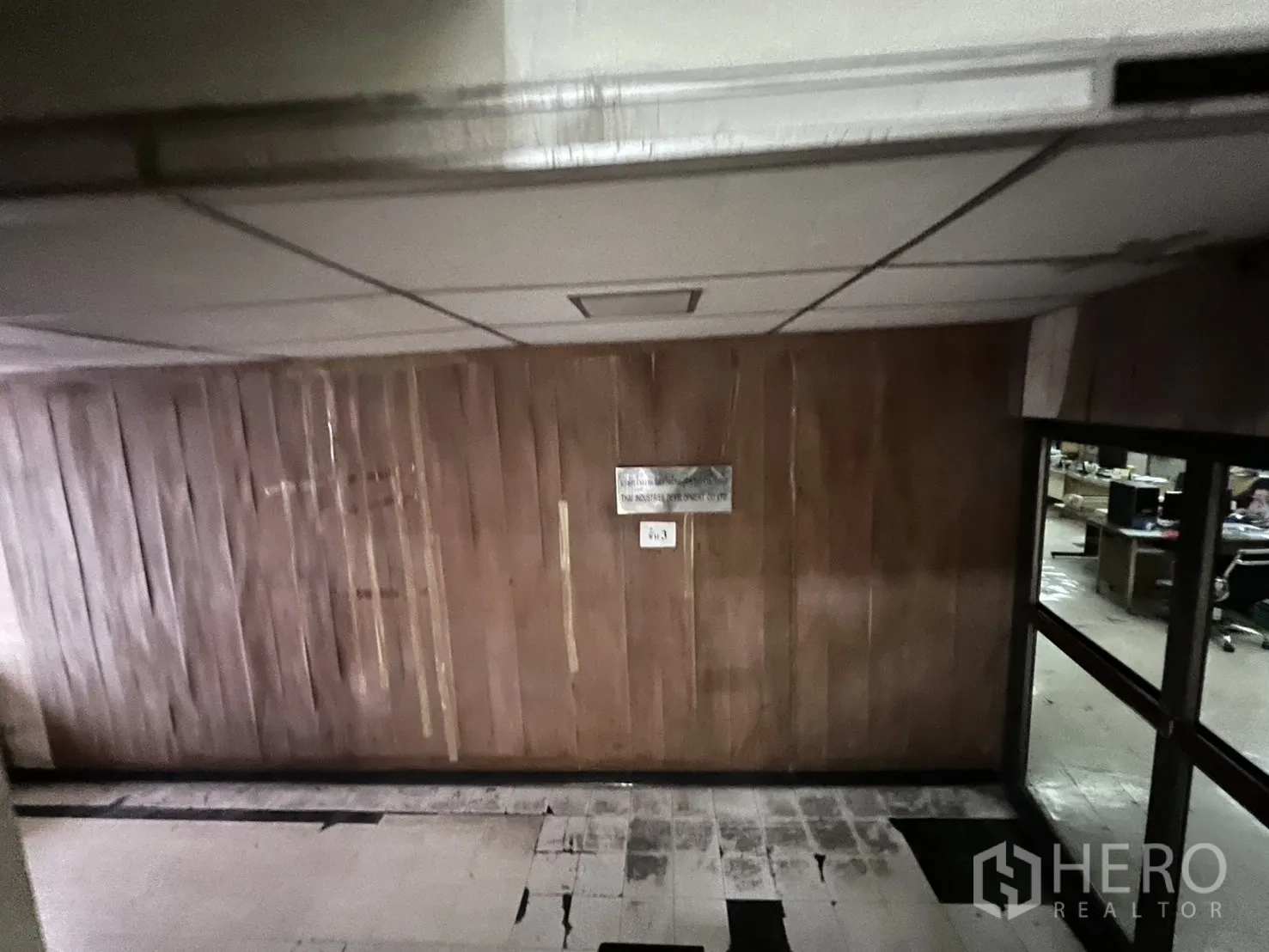 店屋 出租 - 走廊木质墙板与旧地砖，邻近办公室。