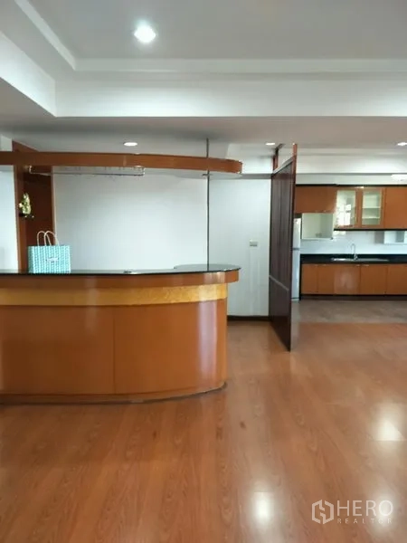 公寓 出租在Watthana, Bangkok - Royal Castle 公寓开放式客厅，木地板与内置吧台，位于曼谷瓦塔那Phrom Phong。