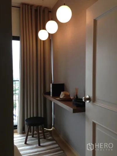 Condominium for rent in Phaya Thai, Bangkok - Compact work area by the balcony with a floating wooden desk, stool and three globe pendant lights.