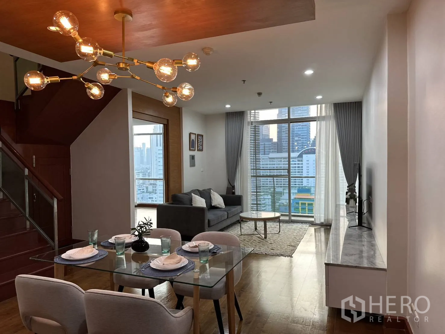 คอนโด for rent in Watthana, Bangkok - พื้นที่นั่งเล่น–รับประทานอาหารแบบโอเพ่น พร้อมโต๊ะกระจก โคมไฟสมัยใหม่ และหน้าต่างสูงจดเพดาน