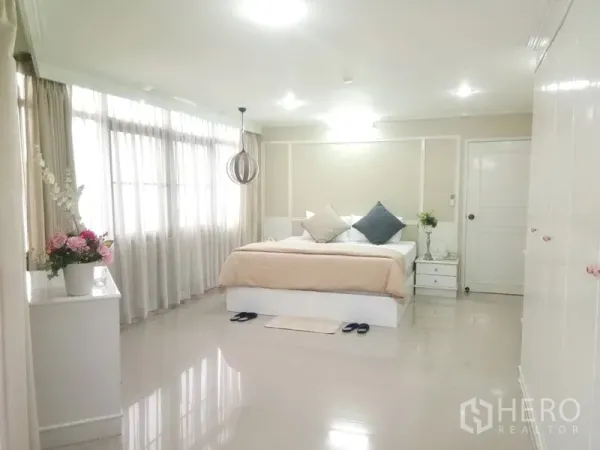 Condominium for rent in Watthana, Bangkok - Spacious master bedroom with large windows, soft lighting and neutral decor.