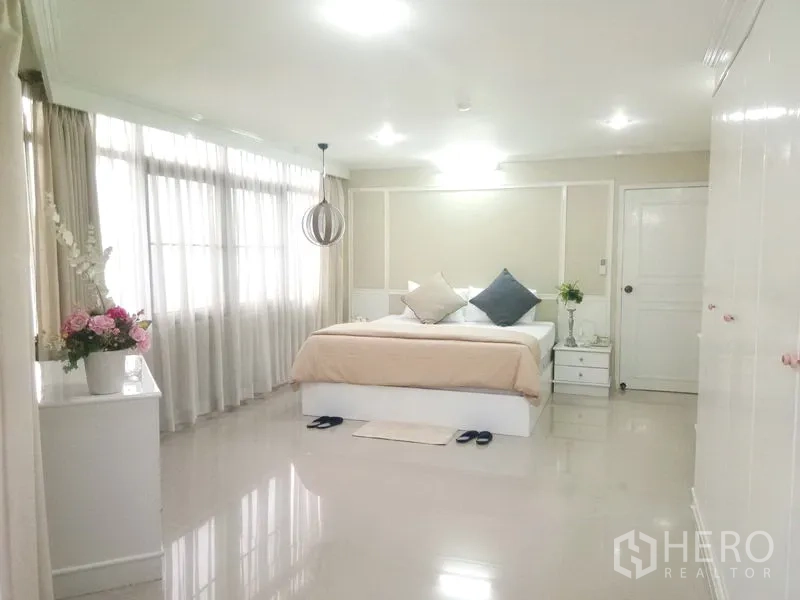 Condominium for rent in Watthana, Bangkok - Spacious master bedroom with large windows, soft lighting and neutral decor.