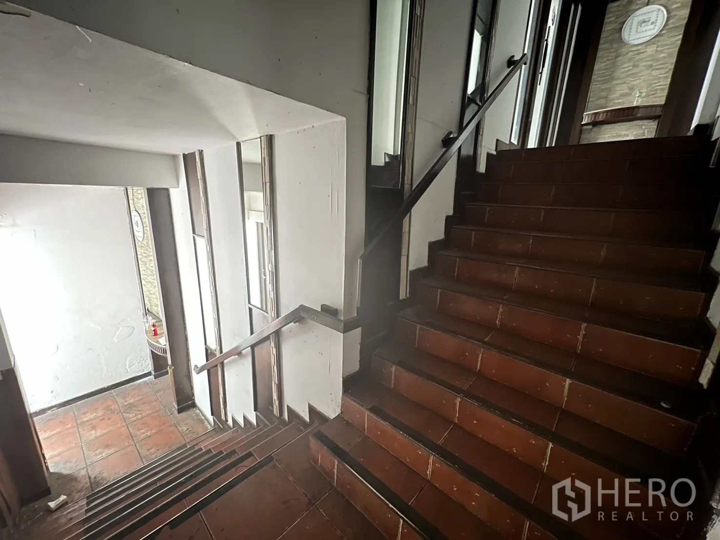 Shophouse for rent in Khlong Toei, Bangkok - Internal stairwell with brown tiled steps, metal handrail and natural light from side windows.