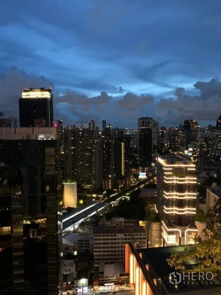 Condominium for rent in Watthana, Bangkok - Night city view from a high-rise balcony overlooking the Bangkok skyline and nearby towers.
