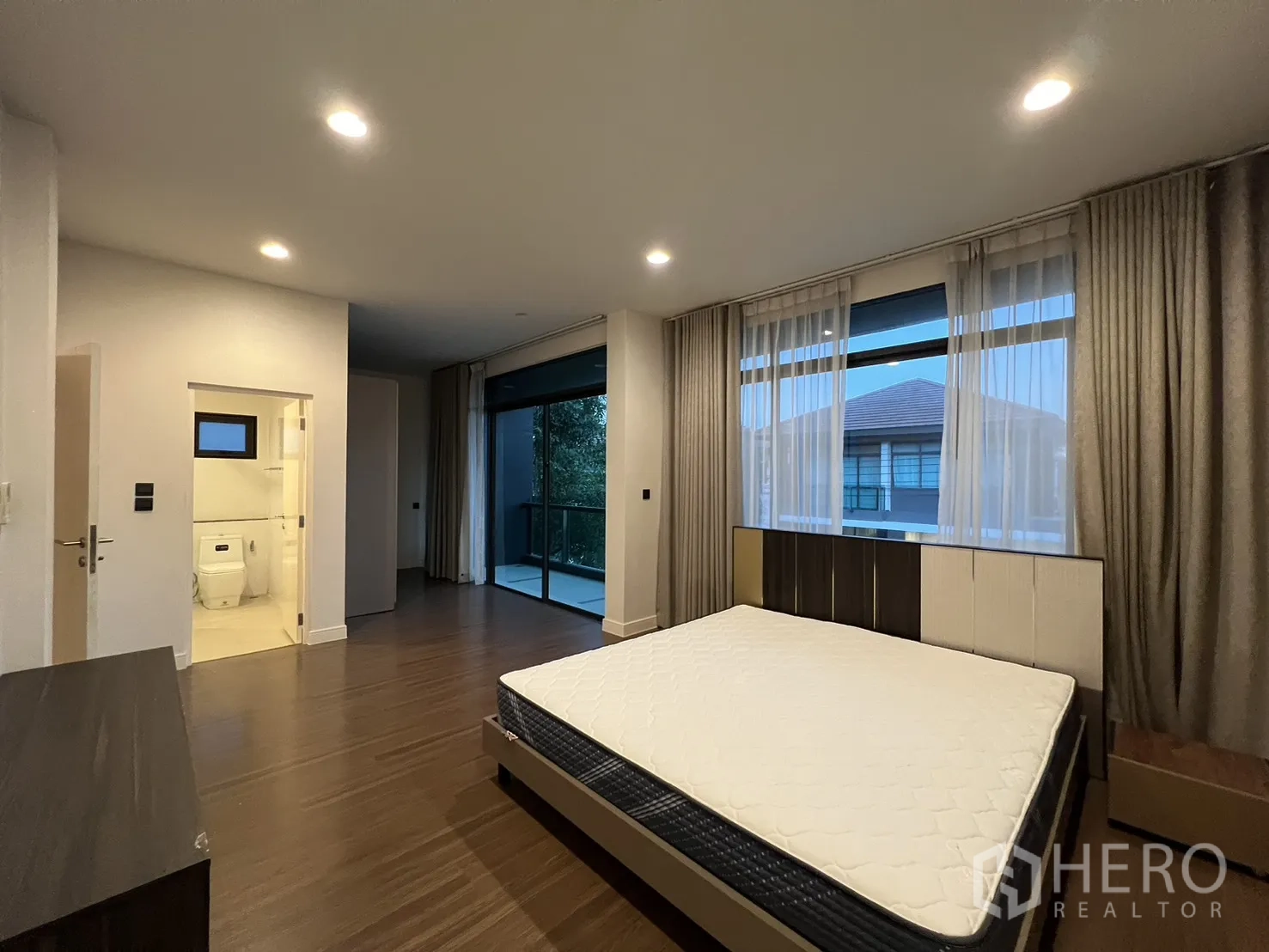 Detached House for rent or sale in Bang Kapi, Bangkok - Master bedroom showing curtains, media cabinet and wood floors.