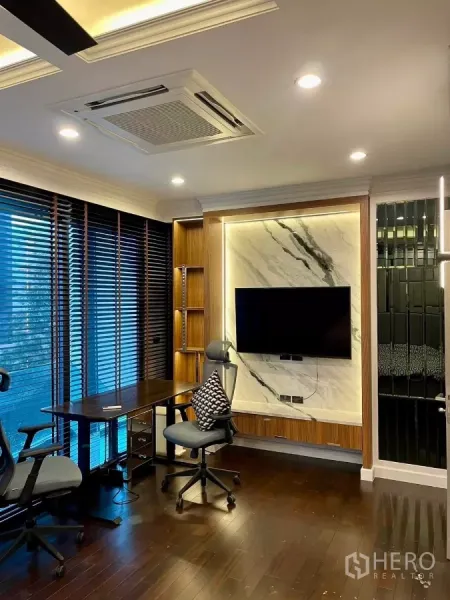 联排别墅 出租在Chatuchak, Bangkok - 明亮书房，木地板，大窗百叶，书桌与大理石背景电视。