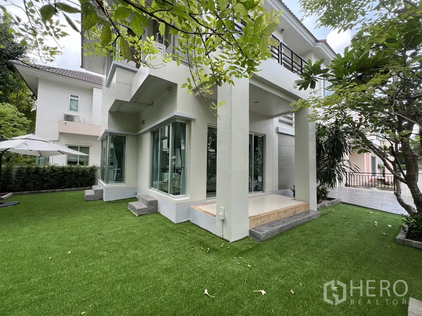 Detached House for rent in Saphan Sung, Bangkok - Rear elevation with covered terrace steps and wraparound lawn.