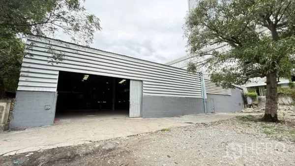 Warehouse for rent in Bang Na, Bangkok - Metal-clad warehouse exterior with wide sliding entry doors and driveway.
