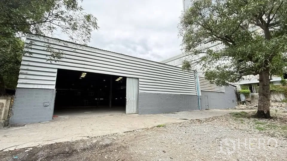 Warehouse for rent in Bang Na, Bangkok - Metal-clad warehouse exterior with wide sliding entry doors and driveway.