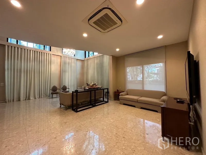 Detached House for rent or sale in Khan Na Yao, Bangkok - Grand double-height living area with marble floors and large windows.