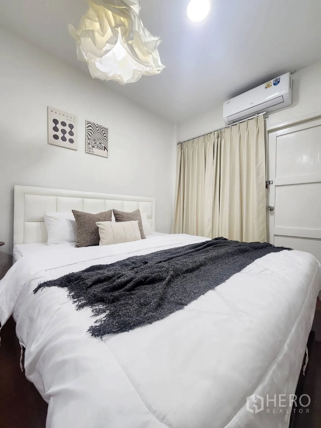 บ้านเดี่ยว for rent in Huai Khwang, Bangkok - ห้องนอนอบอุ่น เตียงสีขาว โคมไฟแขวน แอร์ และผ้าม่านสีครีม