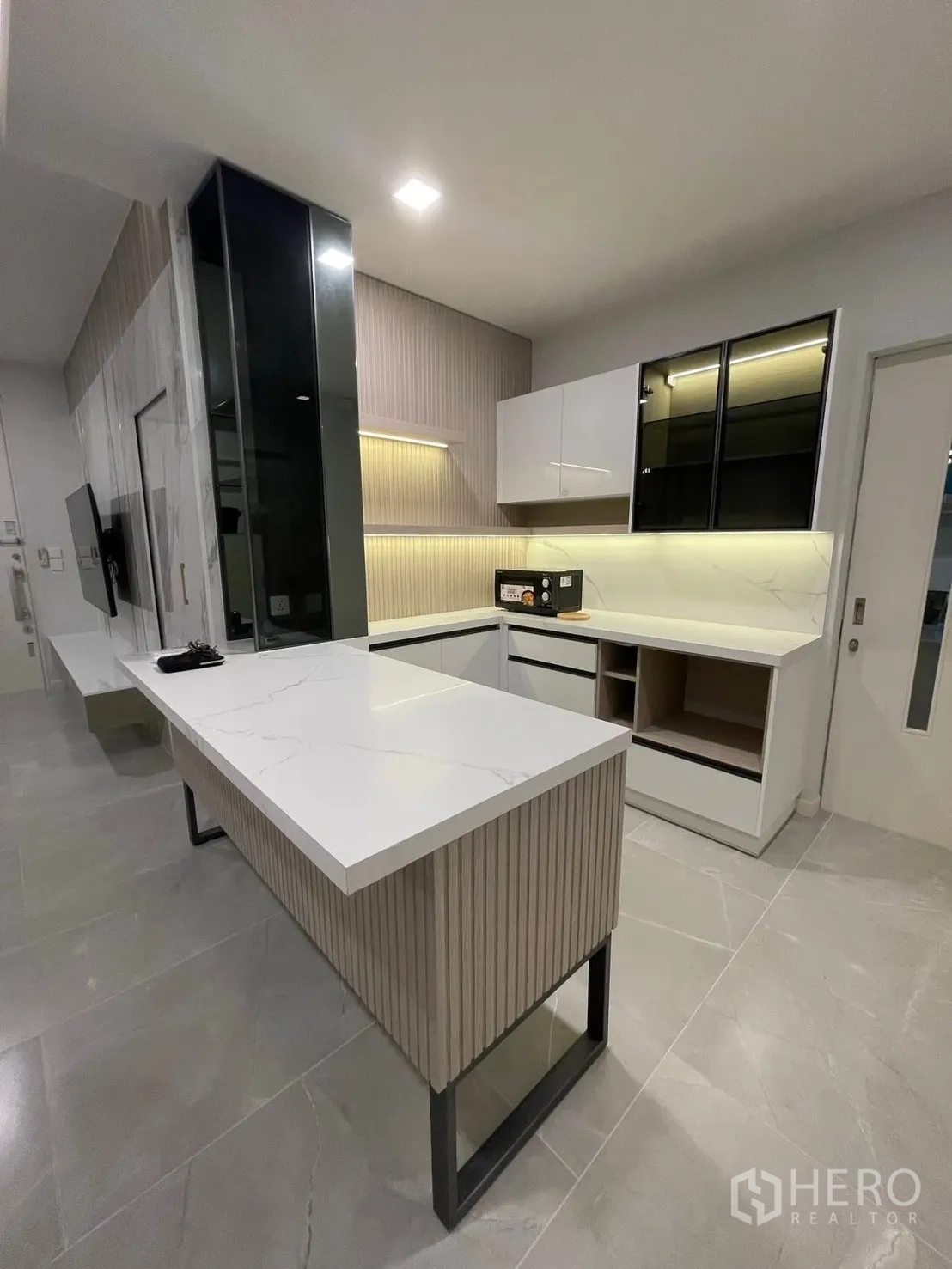 独栋房屋 for rent in Prawet, Bangkok - 现代厨房，长形中岛/吧台，白色台面与灯带橱柜。