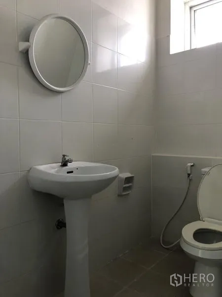 Factory for rent in Bang Sao Thong, Samut Prakan - Clean tiled restroom with pedestal sink, mirror and toilet.
