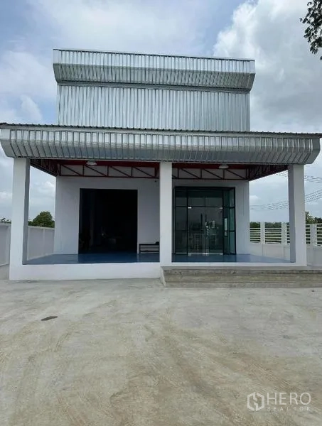 คลังสินค้า ขายในKhlong Luang, Pathum Thani - ด้านหน้าอาคารโกดังพร้อมลานจอดกว้างและกันสาดเมทัลชีท