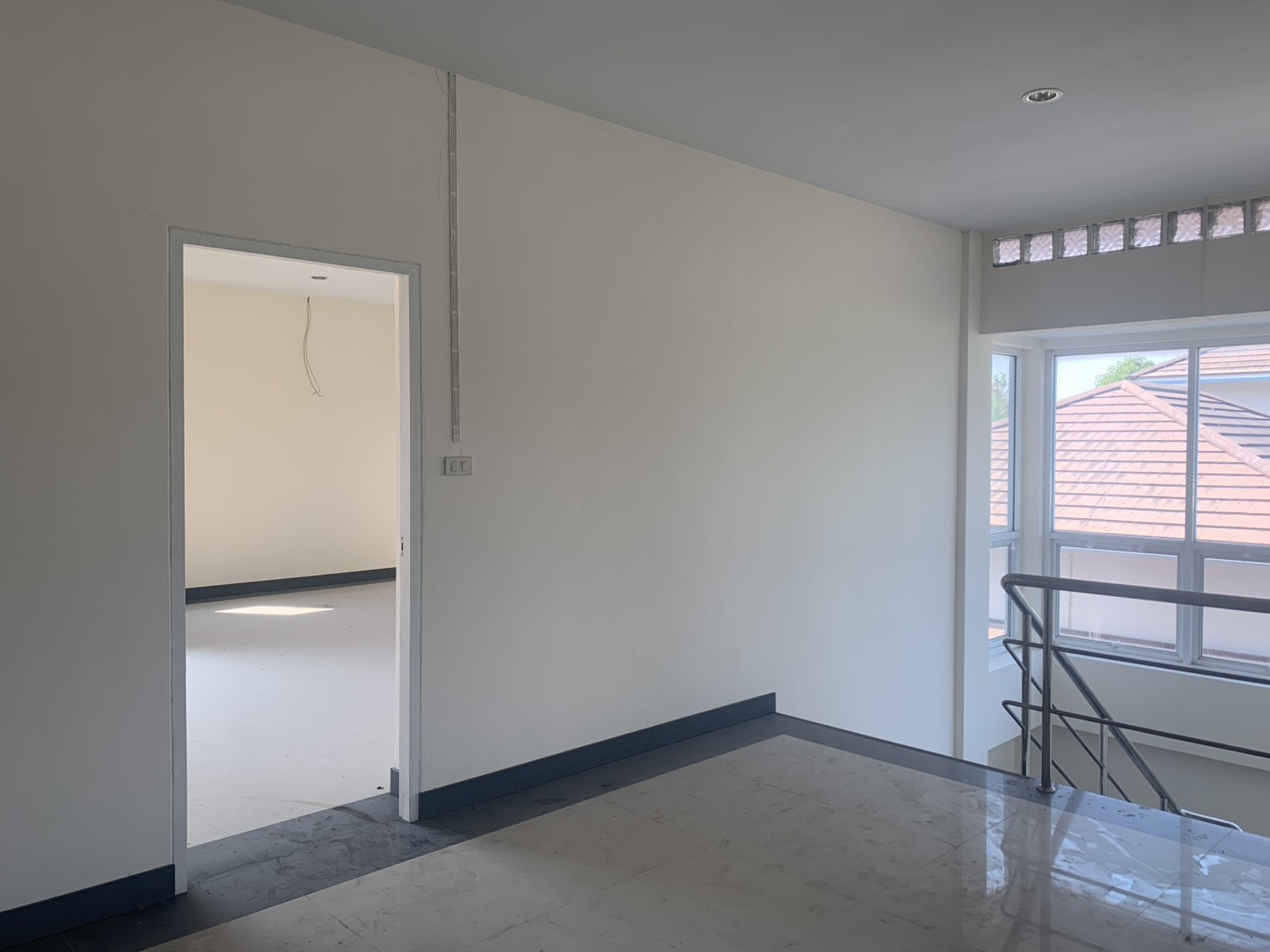 Warehouse for rent in Lam Luk Ka, Pathum Thani - Upper landing with staircase and large windows beside an office room.