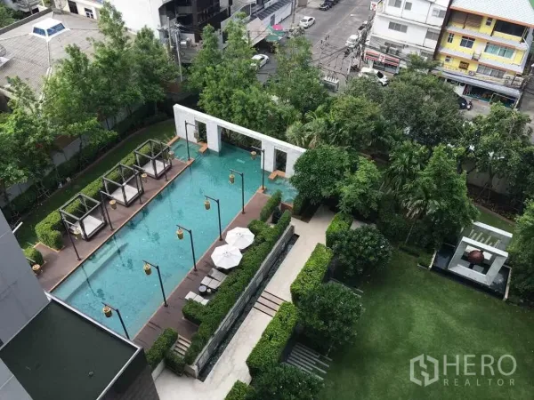 Condominium for rent or sale in Bang Rak, Bangkok - Aerial view of landscaped condominium pool with cabanas and green garden courtyard