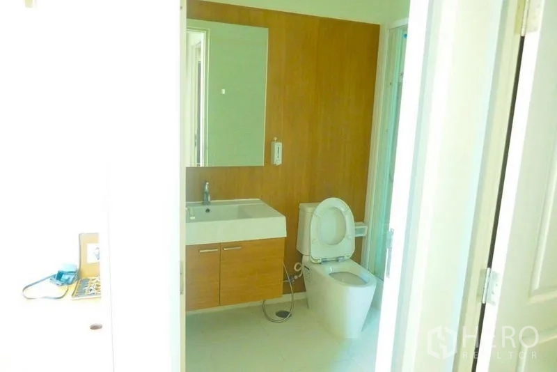 Condominium for rent or sale in Khlong San, Bangkok - Modern bathroom with floating vanity, wall mirror and toilet.
