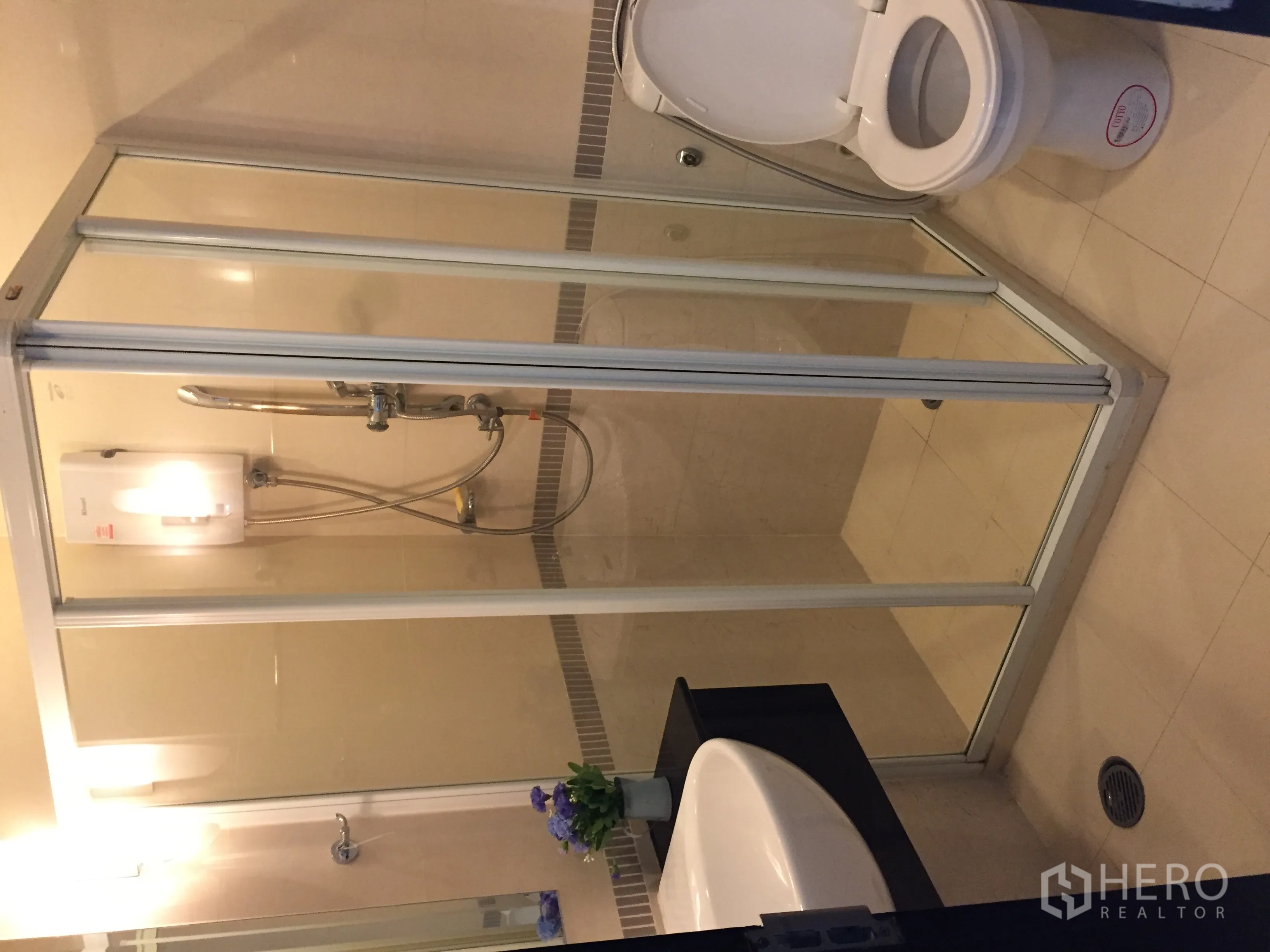 公寓 出租在Ratchathewi, Bangkok - 浴室内玻璃淋浴房、坐便器与即热式热水器。