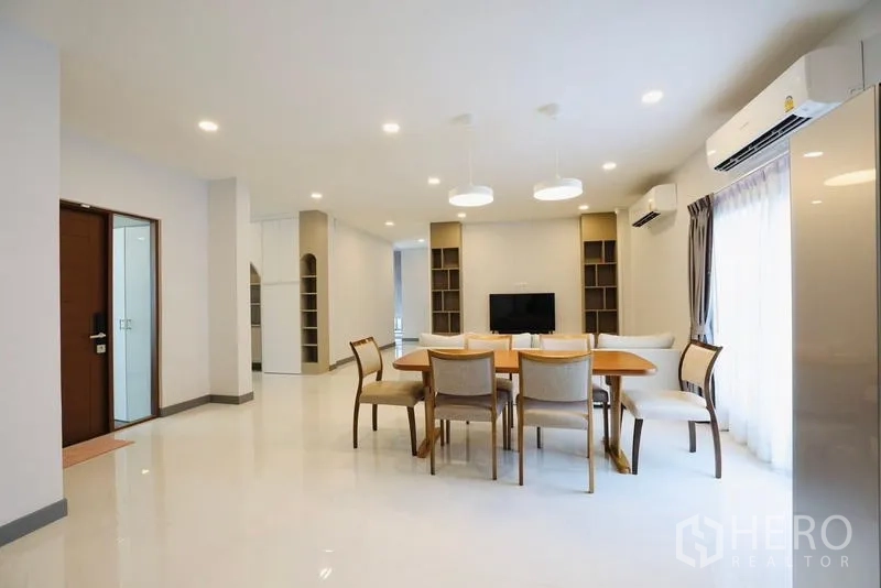 独立式住宅 出租在Bang Phli, Samut Prakan - 餐区面向客厅，吊灯与电视背景墙。